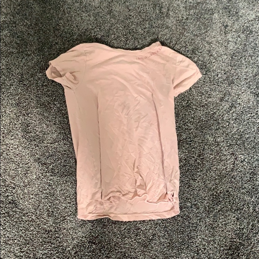 Blush pink top says shipwreck near the collar